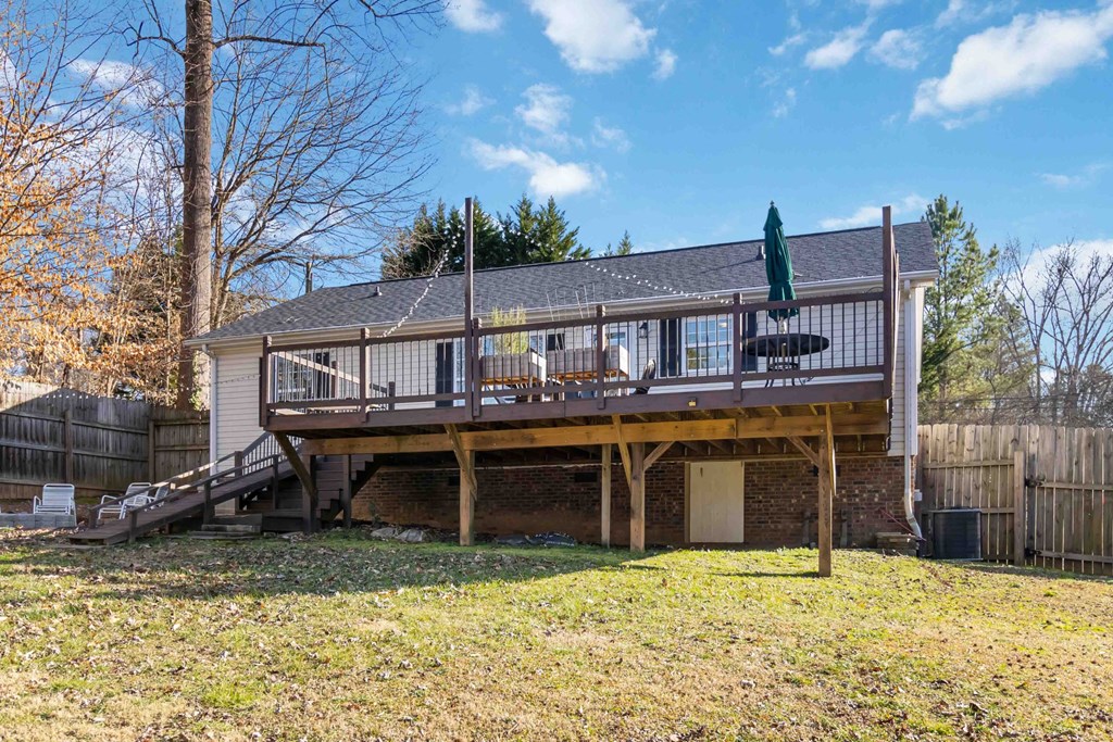 A house with a deck and a green umbrella.
