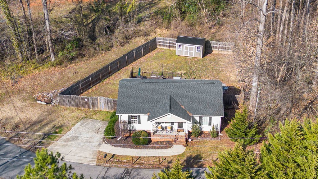 A house with a grey roof and a white fence.