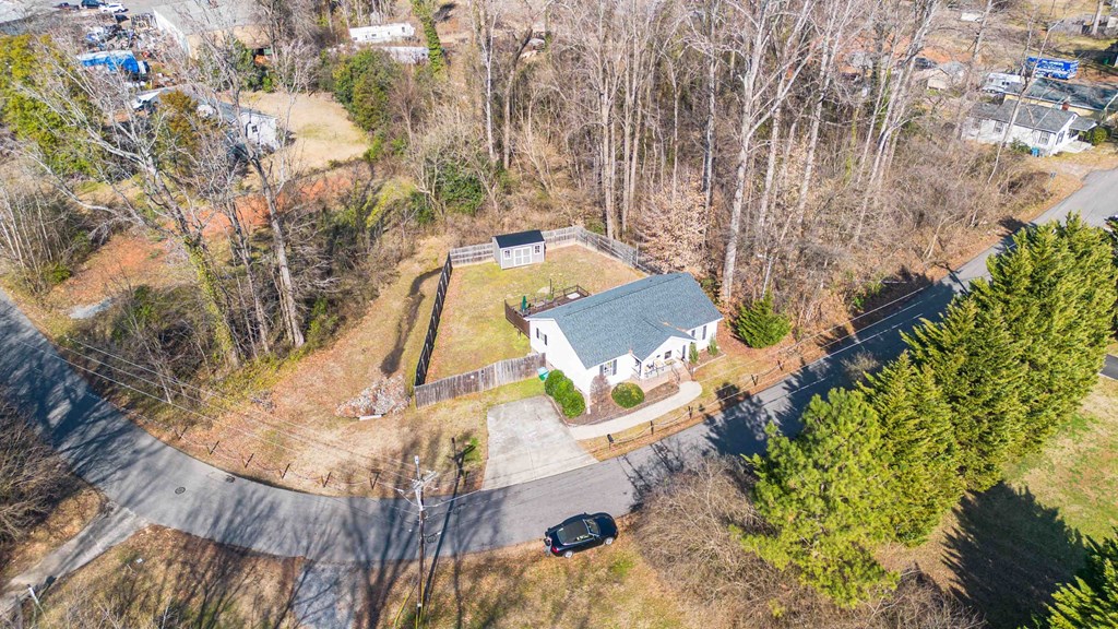 A house with a grey roof is surrounded by trees.