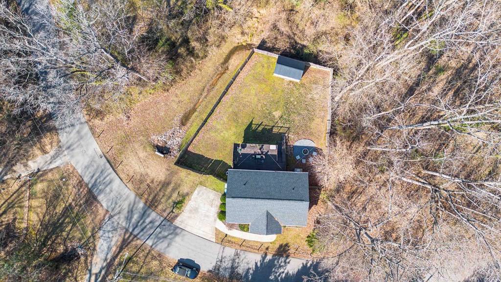 A house with a grey roof is surrounded by trees.