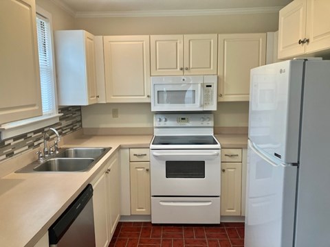 A kitchen with white appliances and cabinets.
