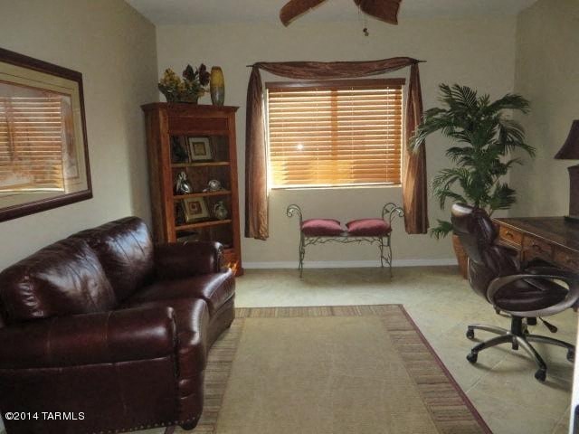 A brown leather couch sits in a living room with a chair and a plant.