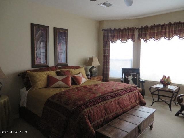 A bedroom with a large bed and a wooden coffee table.