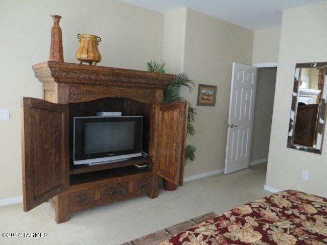 A wooden entertainment center with a television and a vase on top.