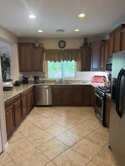 A kitchen with brown cabinets and a black refrigerator.