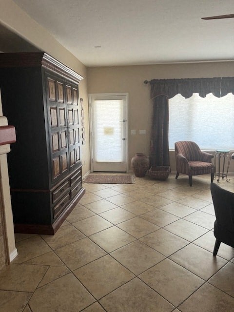 A room with a chair and a table in front of a window.