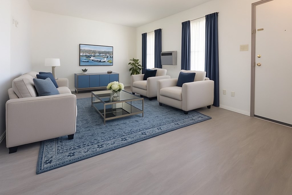 A living room with a blue rug and a painting on the wall.