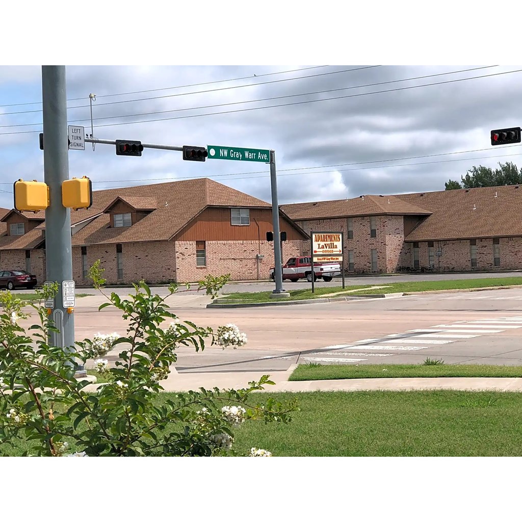 A street view of a residential area with a traffic light and a sign for NW 163rd Ave.