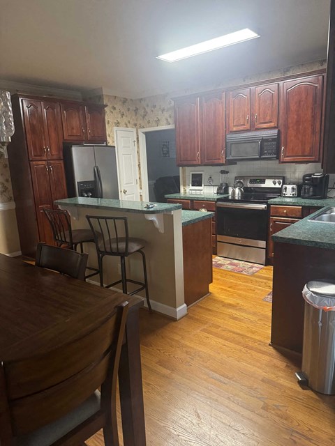 A kitchen with wooden cabinets and a granite countertop.