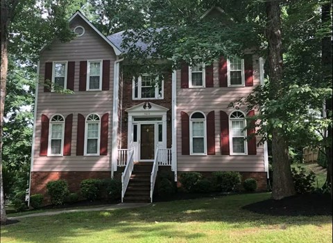 A two-story house with a red and white striped facade.