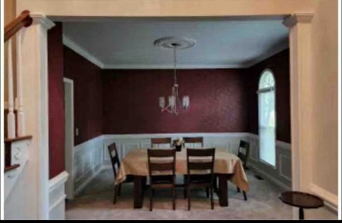 A dining room with a table set for four.