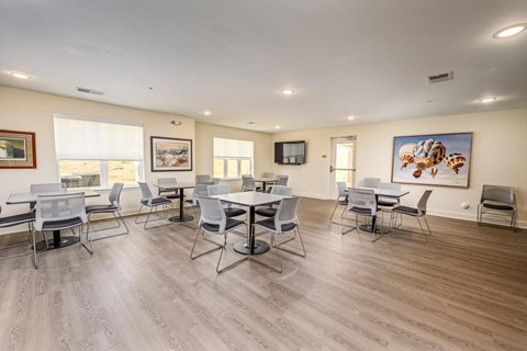 A room with a dining table and chairs.