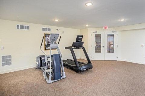 A room with a treadmill and a stationary bike.