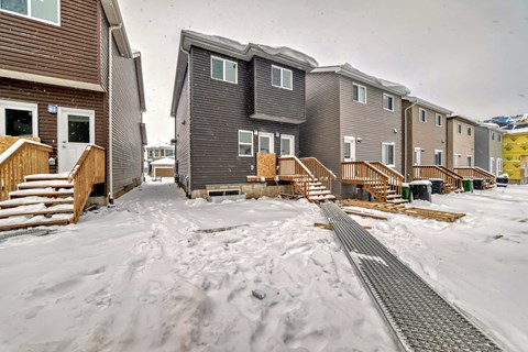 A snowy scene with apartment buildings and a pathway.