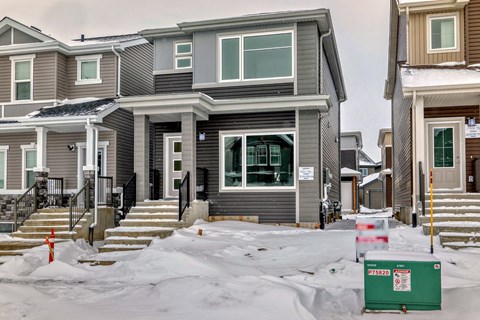 A row of houses with snow on the ground.