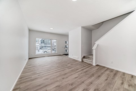 A room with wooden flooring and white walls.