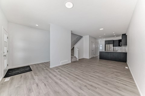 A spacious room with a staircase leading to the upper floor.