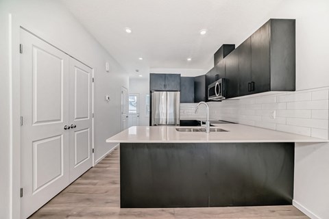 A modern kitchen with a large island and stainless steel appliances.