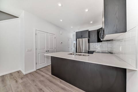 A modern kitchen with a dark countertop and stainless steel appliances.