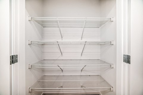 Empty refrigerator with four shelves.