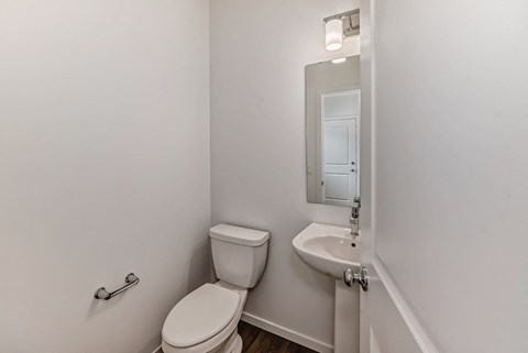 A white toilet and sink in a small bathroom.