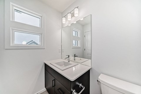 A bathroom with a white sink and a mirror.