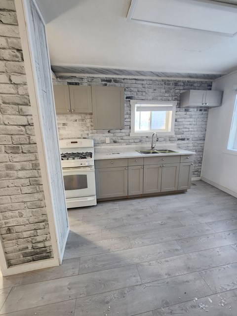 A kitchen with a brick wall and a window.