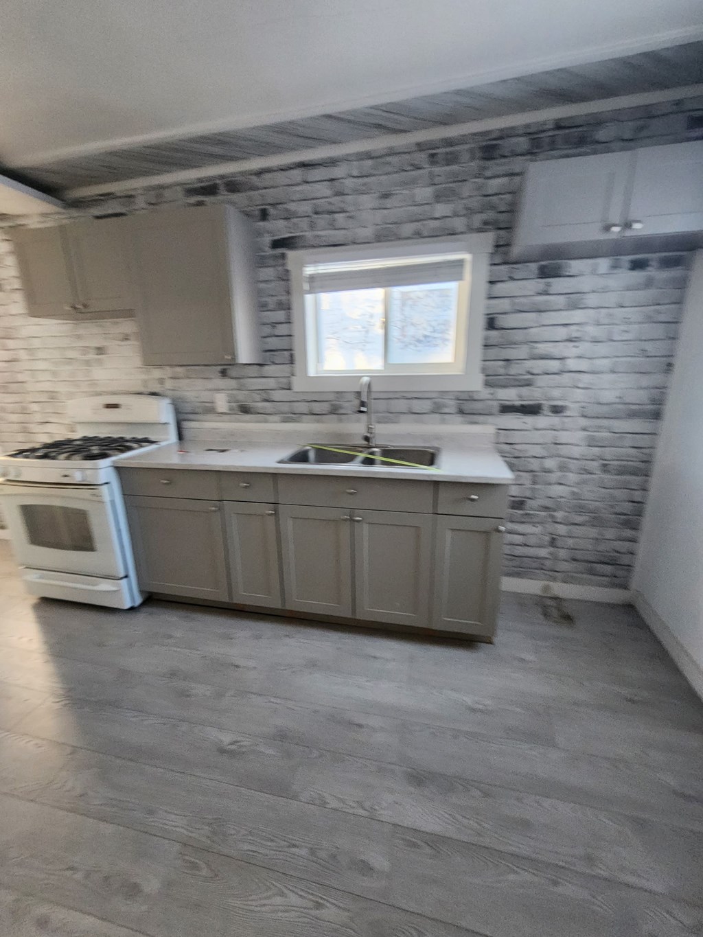 A kitchen with a white oven and a window above the sink.
