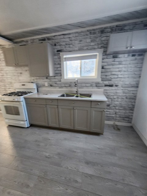 A kitchen with a white oven and a window above the sink.