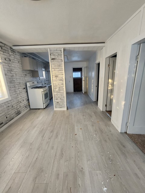 A kitchen area with a white brick wall and a white oven.