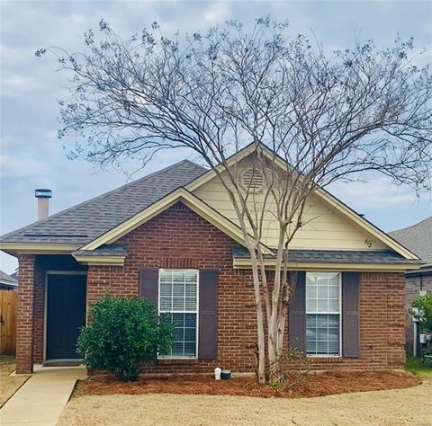 A house with a tree in front of it.