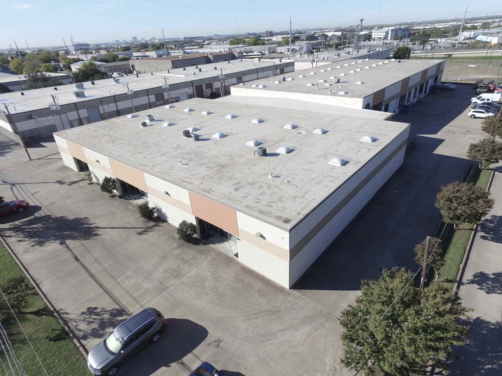 A large building with a flat roof and a parking lot in front.