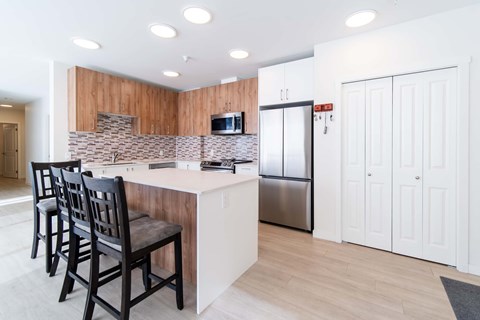 A kitchen with a white counter and a refrigerator.