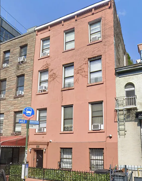 A red building with a blue sign on the corner.