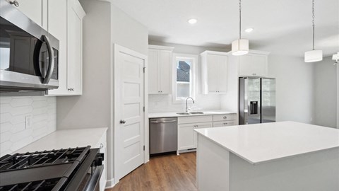 A modern kitchen with white cabinets and a large island.