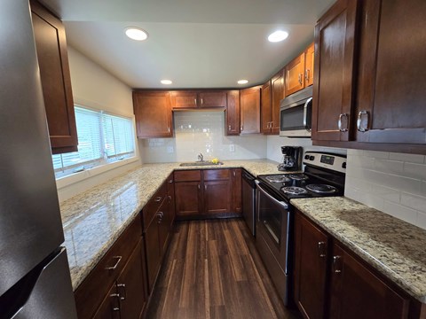 A kitchen with wooden cabinets and a granite countertop.