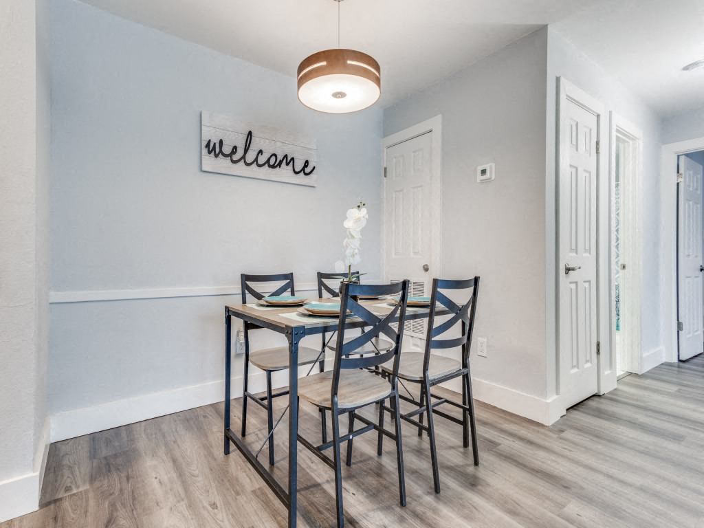 A dining room with a table set for four.