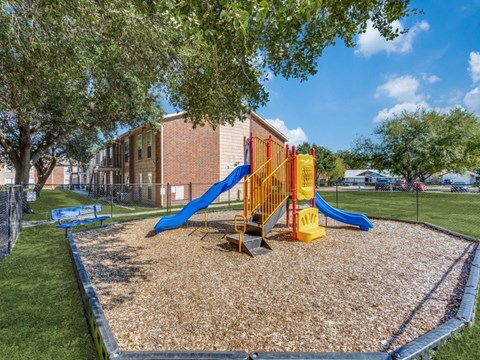 A playground with a yellow and blue slide.