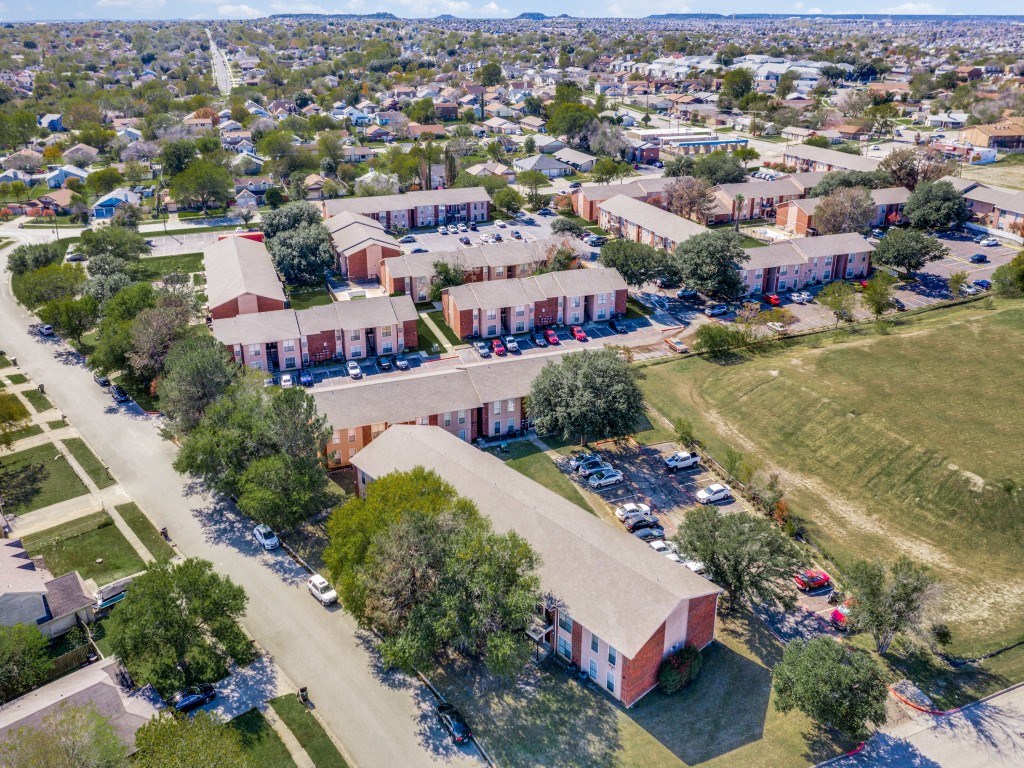 A large building complex with a parking lot in front.
