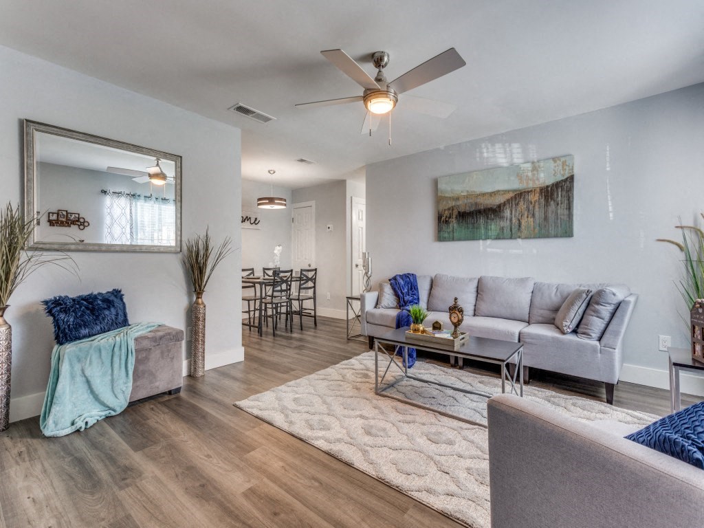 A living room with a grey couch, a coffee table, and a painting on the wall.