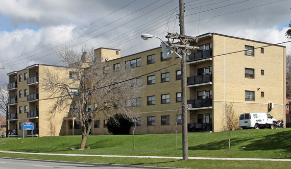 Apartment building with a white van parked in front.