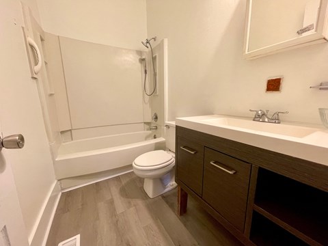A white toilet is in a bathroom next to a sink.