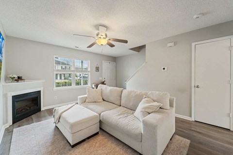 A living room with a white couch and a fireplace.