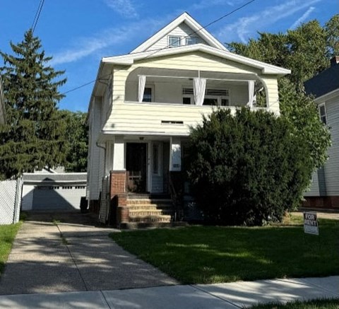 A two-story house with a front porch and a garage.