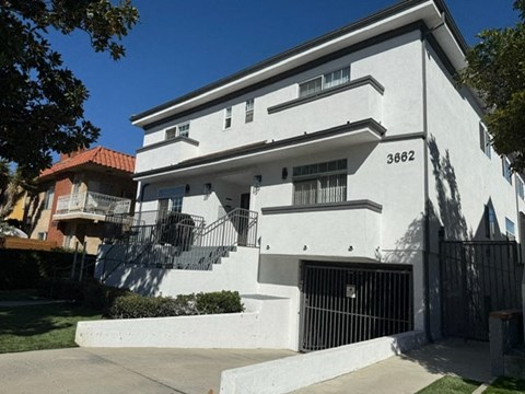 A white two-story house with black iron railings on the balconies.