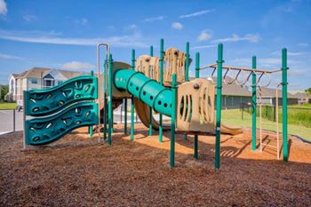 A playground with a green and yellow slide at Mode at Melbourne, LLC Apartments, Melbourne, Florida