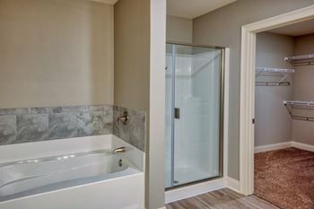A bathroom with a white tub and a glass shower door at Mode at Melbourne, LLC Apartments, Florida