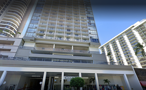 A tall white building with balconies and a sign that reads "Bank of Lisbon".