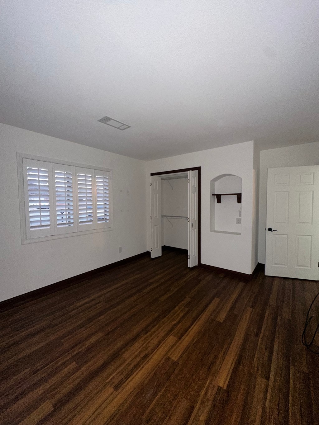 A room with a wooden floor and white walls.