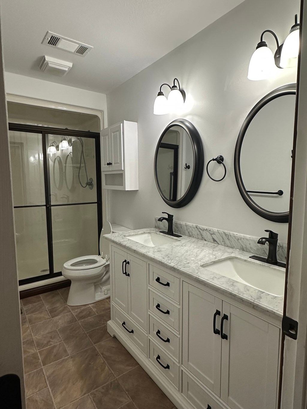 A bathroom with a toilet, sink, and mirror.